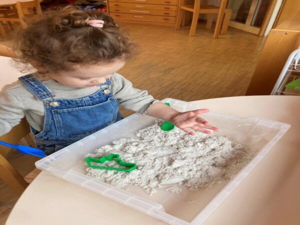 Ein kleines Mädchen spielt mit Knete